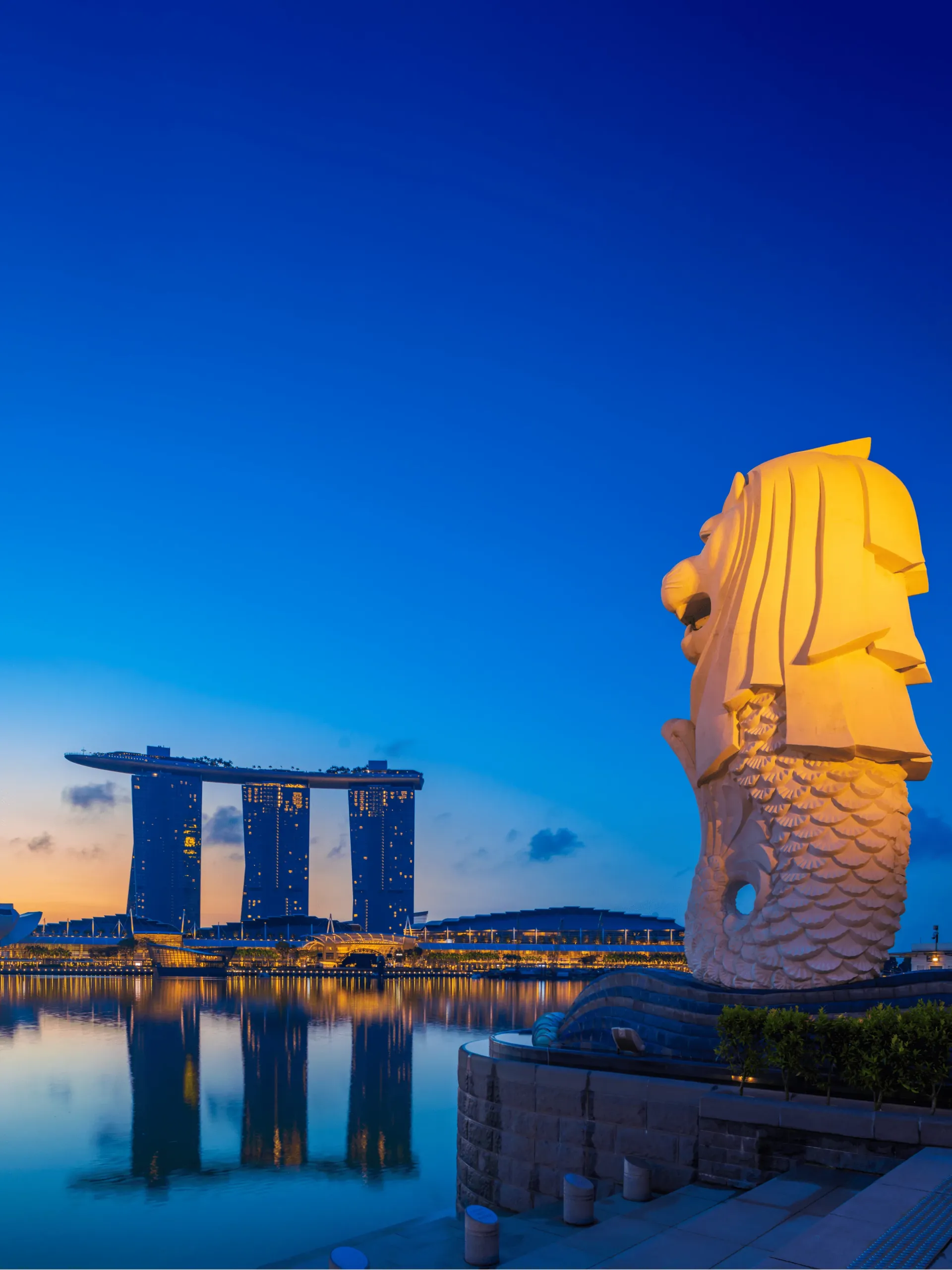 Merlion statue and Marina Bay Sands at dusk in Singapore. It illustrates pay-per-click advertising in digital marketing in Singapore.