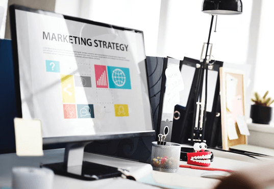 Laptop showing marketing strategy on a desk. It supports attracting your target audience with an online business strategy.